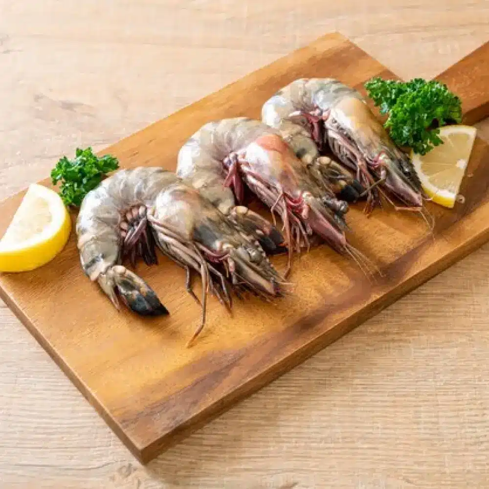 Crevettes tigrées fraîches sur une planche en bois